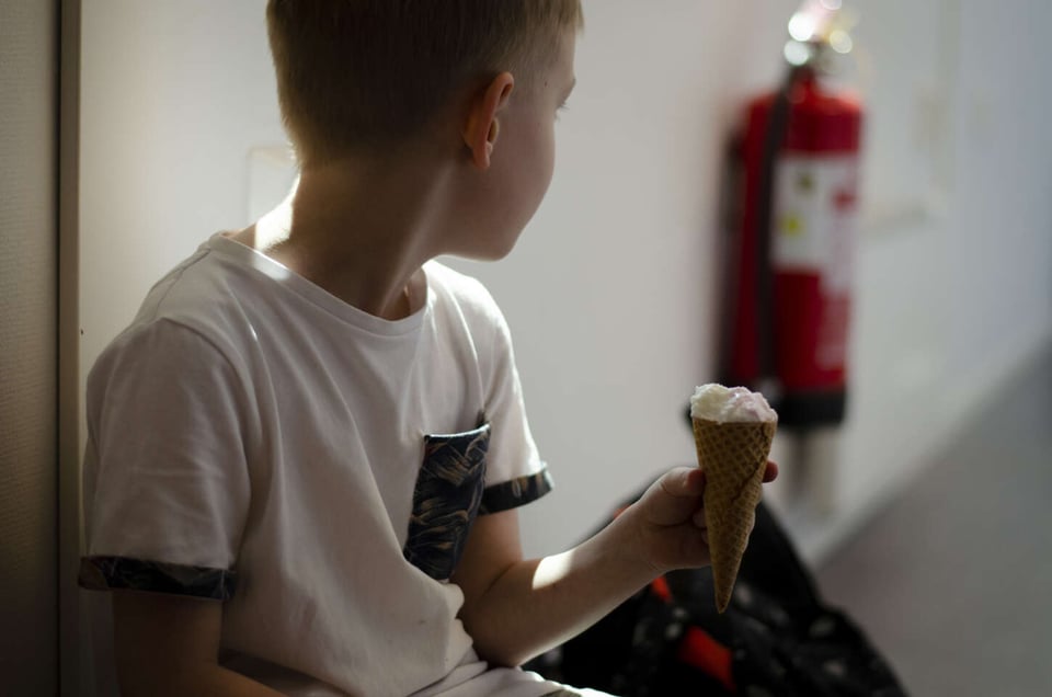 Foto van een kind in een modulair gebouw dat kijkt naar een brandblusser aan de muur